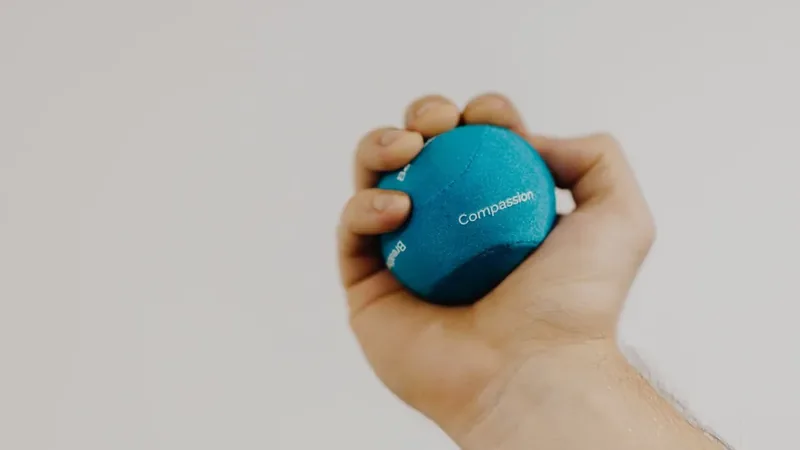 Mão apertando uma bolinha de borracha, um dos exercícios para dedo em gatilho que pedem cuidado