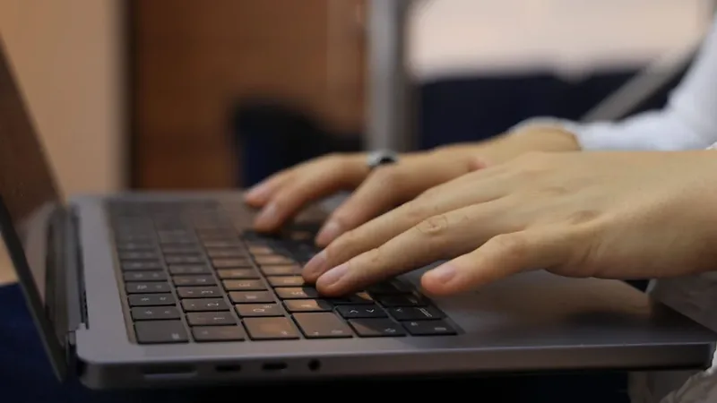 Mãos digitando em um notebook, atividade que piora a síndrome do túnel do carpo sem tratamento