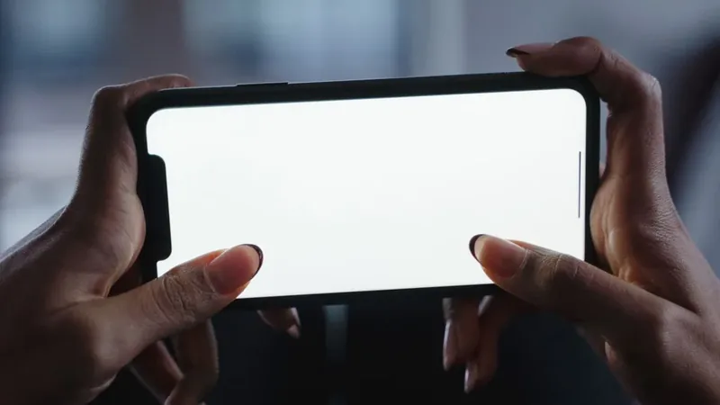 Mãos segurando um celular com os polegares em uso, gesto que agrava a tendinite de De Quervain